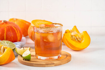 Thanksgiving Margarita, Sweet Pumpkin Shrubs cocktail, alcohol tasty autumn drink on white background with slices pumpkins, copy space