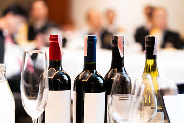Wine bottles and wine glasses are arranged on a table at a luxurious banquet