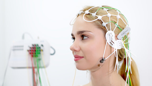 EEG sensors on the head of a young female patient for brain testing in a medical center. Ideal for showcasing advanced diagnostics and professional healthcare settings.