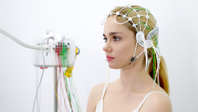 EEG sensors on the head of a young female patient for brain testing in a medical center. Ideal for showcasing advanced diagnostics and professional healthcare settings.