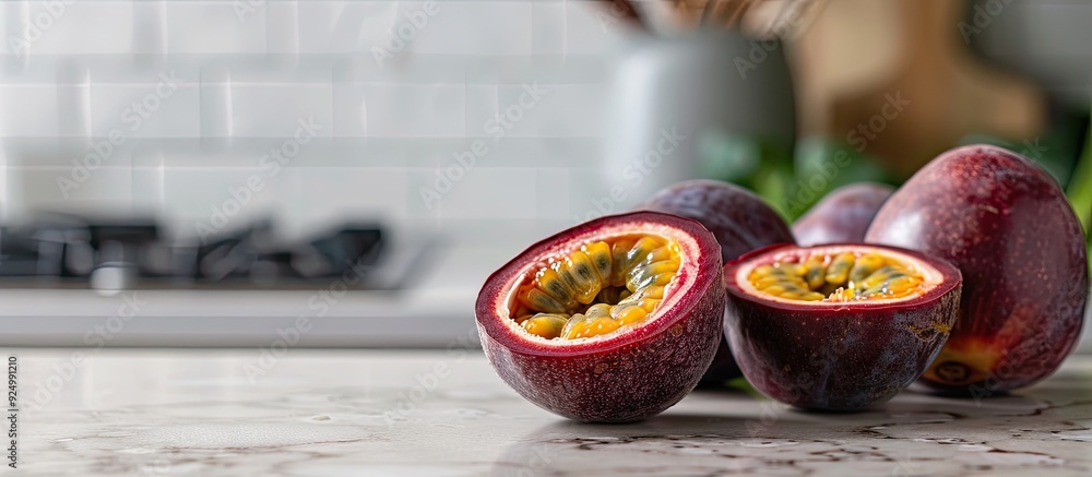 Poster passionfruit sliced on a kitchen counter part of a healthy diet with a neutral textured tile backdro
