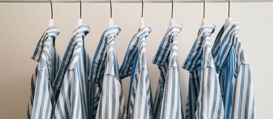 A lineup of men s blue striped long sleeved shirts hanging against a white backdrop ideal for a copy space image