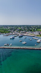 Fototapeta premium New Shoreham, RI, USA - August 5 2024: Vertical aerial image of Old Harbor, Block Island, New Shoreham, RI and local downtown area and ferry terminal. 
