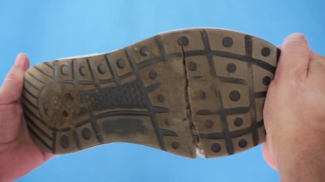 Old worn out ripped sneakers. Low-quality shoes with broken soles, close-up. Shoe repair