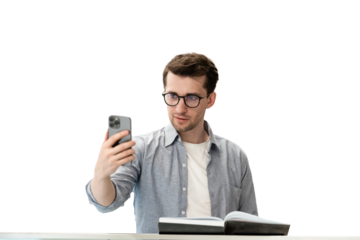 Young handsome dark haired man in glasses  with notebook making video call by phone against transparent background. Calm student holding smartphone, calling parents ..Education and business concept.