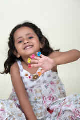  A delightful little girl with sparkling eyes, breaking into a wide, infectious smile. Her expression radiates pure happiness and innocence.