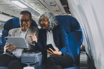 Happy elderly senior couple of travelers with suitcase in airport
