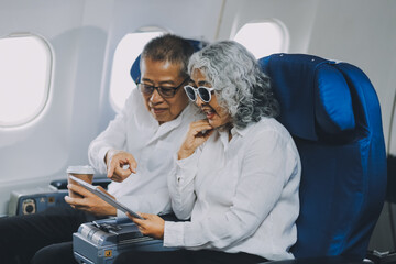 Happy elderly senior couple of travelers with suitcase in airport