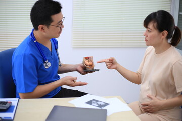 Obraz premium Male doctor with experience examining young pregnant women