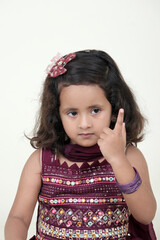  A delightful little girl with sparkling eyes, breaking into a wide, infectious smile. Her expression radiates pure happiness and innocence.