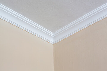 White plasterboard ceiling decorations in the corner of a room. Corrugated plasterboard panels.