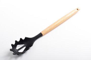 Black plastic spoon for draining of spaghetti isolated on white background