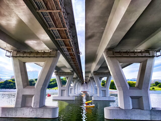 Beneath a beautifully designed Modern Bridge that stands over peaceful and calm water,