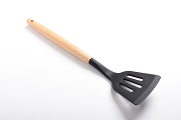Kitchen spatula on isolated white background. Black silicone spatula with wooden handle. Cooking utensil