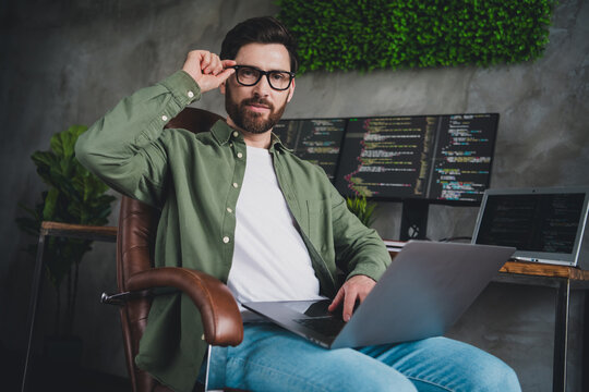Portrait of professional hacker young man laptop computer desk loft interior office indoors