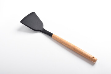 Kitchen spatula on isolated white background. Black silicone spatula with wooden handle. Cooking utensil