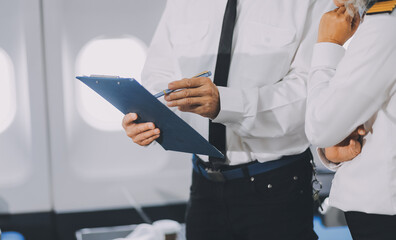 Professional pilot woman in uniform has teamwork meeting for success flight in aviation business. Young female captain instructor sitting in office and working or training commercial airline crew. © ARMMY PICCA