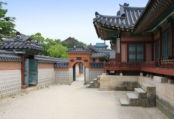 Jongno-gu, Seoul, South Korea - May 25, 2022: Summer view of yard and entrance door with stonewall and tile roof houses at Gyeongbokgung Palace