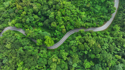 Aerial view of road in the middle of the forest , Top view road curve construction up to mountain,...