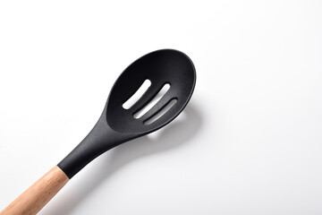 Close up Kitchen spatula on isolated white background. Black silicone spatula with wooden handle. Cooking utensil