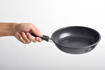 Hand holding Black frying pan with a non-stick coating isolated on white background