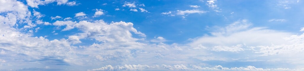 Panoramic background with blue sky with white fluffy clouds