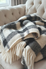 A cozy plaid blanket, folded neatly on a pastel cream background, perfect for fall evenings,