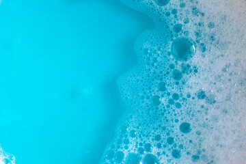 Foam in blue water. Blue foam. Water with foam bubbles. Blue background