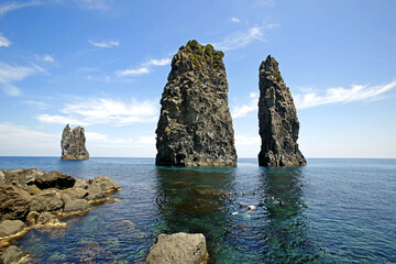 Cheonbu-ri, Ulleung-gun, Gyeongsangbuk-do, South Korea - June 17, 2022: Summer view of tourists snorkeling on the sea against Samseonam Rocks and horizon