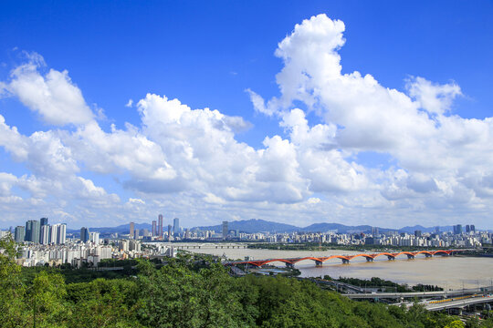 Sangam-dong, Mapo-gu, Seoul, South Korea - July A, 2022: High anglew view of World Cup Bridge on Han River against downtown and cumulus in the sky seen from Sky Park in summer