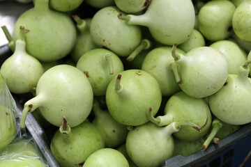 Calabash stacked together in a basket. Fresh raw organic green bottle gourd sold at the market.
