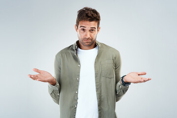 Man, portrait and confused by choice, doubt or decision in white background with hand gesture in...