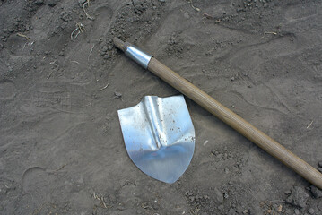 A broken shovel in the garden, hard farm work.