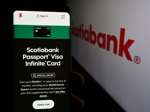 Stuttgart, Germany - 08-12-2024: Person holding smartphone with web page of financial company Bank of Nova Scotia (Scotiabank) in front of logo. Focus on center of phone display.