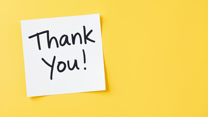 White sticky note with thank you note on yellow background