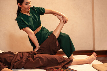 Thai massage, Asian woman professional masseuse service massaging a woman customer through...
