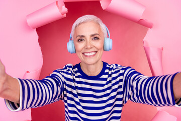 Photo of cheerful woman wear striped trendy clothes breaking paper wall recording video isolated on...