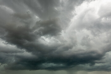 Huge dark cumulus bad weather storm clouds with visible rainfall