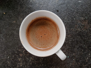A white coffee cup with espresso on the table