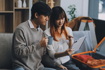 Young Asian couple relocating to a new house, joyfully packing and unpacking belongings. Expertise in moving, packing, togetherness, and creating a new home together.