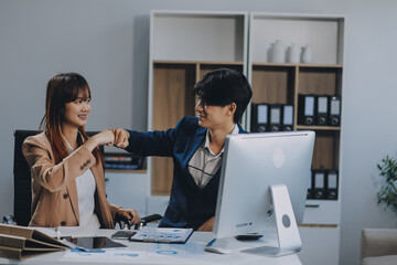 Entrepreneur Asian businessman and businesswoman discussing new business project in tablet in modern Meeting In Modern Office, Asian business casual concept.