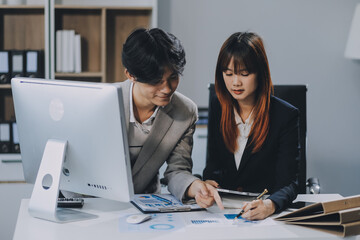 Entrepreneur Asian businessman and businesswoman discussing new business project in tablet in modern Meeting In Modern Office, Asian business casual concept.