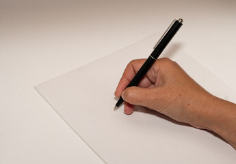 Closeup of a hand with pen and white paper