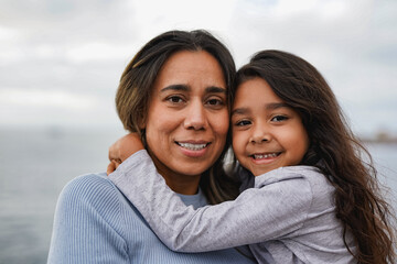 Happy latin mother and little daughter having tender moment outdoor - Family and love concept -...