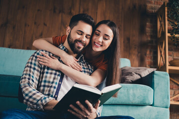 Photo of happy young couple read book hugging move new place enjoy live together have fun new apartment room light house flat indoor