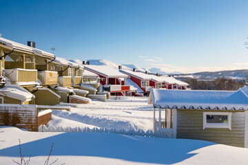 Norwegian traditional houses of Troms in the winter. Snowy arctic city with colorful houses and port