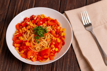 Tomato spaghetti in white plate on a wooden table. Tomato sauce pasta is classic italian cuisine dish. Popular italian food.