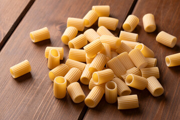 Mezzi rigatoni crudi su sfondo di legno, formato di pasta italiana, gastronomia europea 