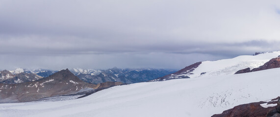 Obraz premium high mountain glacier in cloudy weather with distant mountains in the background