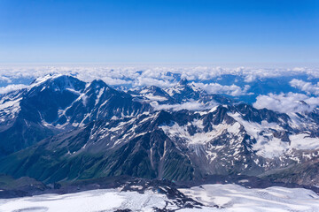 top view of the high mountains above the clouds from the slope of Mount Elbrus